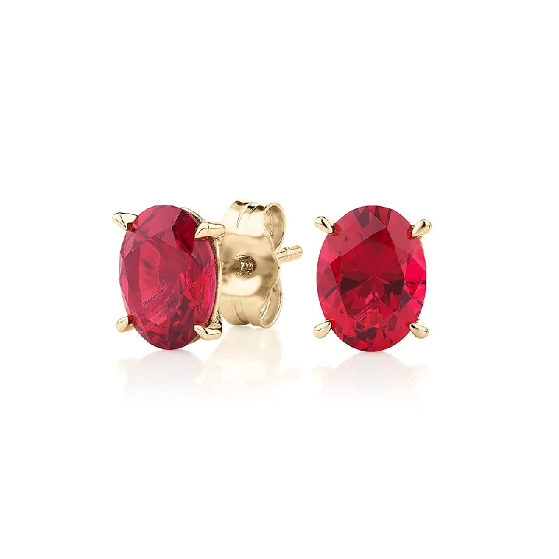 women's minimalist stud earrings-Oval stud earrings with ruby simulants in 10 carat yellow gold