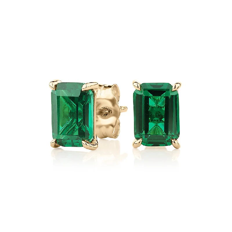 women's silver earrings-Emerald Cut stud earrings with emerald simulants in 10 carat yellow gold